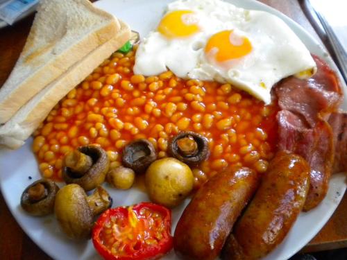 a plate of breakfast food with eggs sausage and beans at Rehoboth Mountain Suites in Mbabane