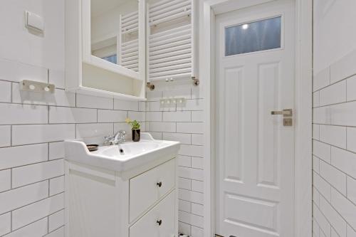 a white bathroom with a sink and a mirror at BE IN GDANSK Apartments - IN THE HEART OF THE OLD TOWN - Mariacka 31/33 in Gdańsk