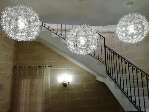 two large chandeliers hanging from a staircase in a house at Sixty Two #4 in Victoria
