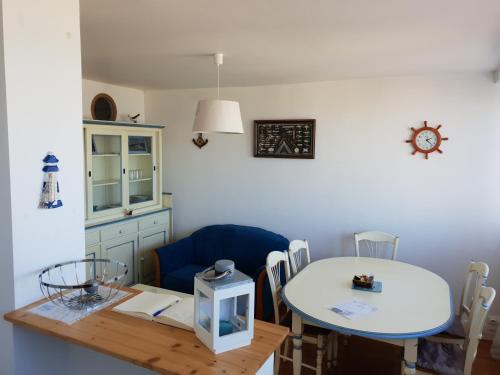 a dining room with a table and a blue chair at Goéland in Le Tréport