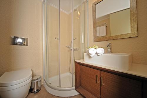 a bathroom with a shower and a toilet and a sink at Pepi Boutique Hotel (Adults Only) in Rethymno Town