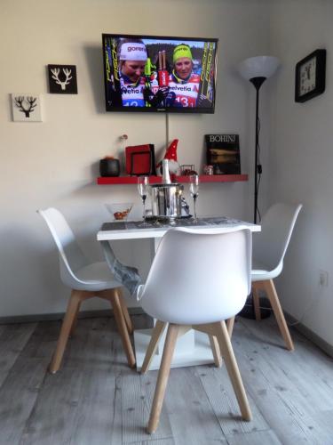 a dining room table with two white chairs at Snežak (Snowman) in Bohinj