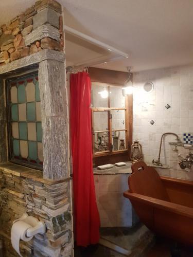 een badkamer met een rood douchegordijn en een bad bij Casa Larice in Mergoscia