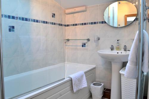 un bagno con vasca e lavandino di Petrock Holiday Cottages a Newton Saint Petrock