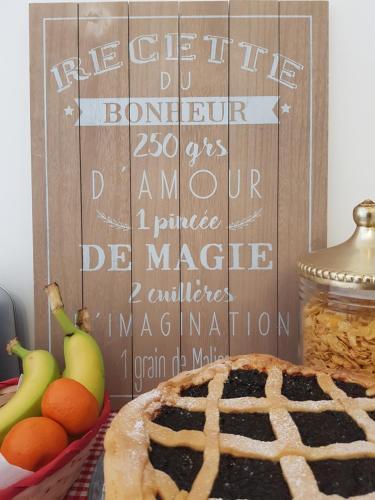 a table with a sign with a cake and fruit at La Viola e il Sole - alloggi e glamping - in Fermo