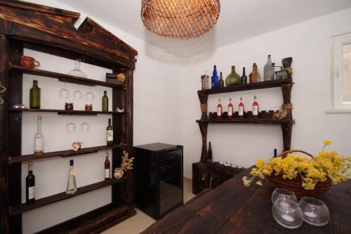 a room with a table and shelves of wine bottles at Villa Putto in Vela Luka