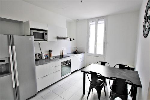 une cuisine avec une table, des chaises et un réfrigérateur dans l'établissement RUE D'ANTIBES CENTER, à Cannes