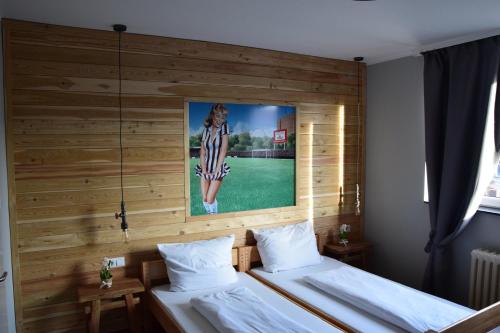 two beds in a room with a picture on the wall at Hamburger Alm Hotel St. Pauli in Hamburg