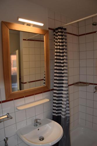 a bathroom with a sink and a mirror and a tub at Hamburger Alm Hotel St. Pauli in Hamburg