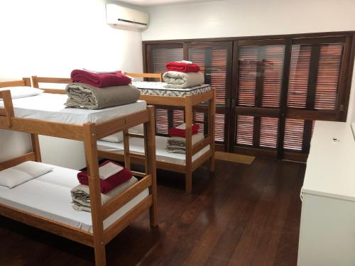 a room with three bunk beds and wooden floors at Hostel Berghaus in Florianópolis