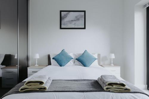- une chambre avec un lit blanc et des oreillers bleus dans l'établissement Weaver House, à Chester
