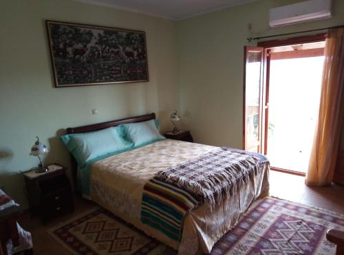 Un dormitorio con una cama y una puerta corrediza de vidrio. en Villa Silvia, en Ágios Matthaíos