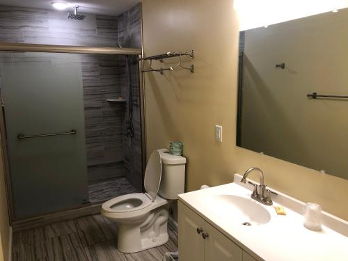 a bathroom with a shower and a toilet and a sink at Anchor Motel in Seaside Heights