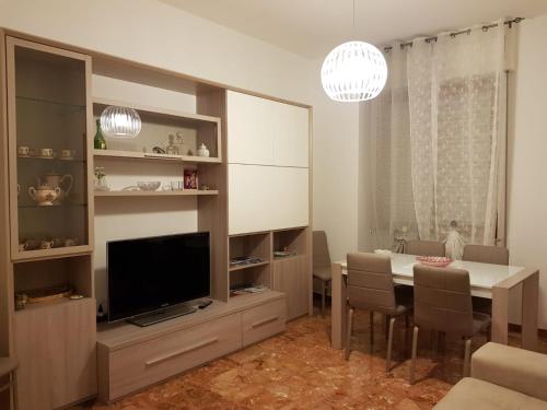 ein Wohnzimmer mit einem Esstisch und einem TV in der Unterkunft Luisa Appartamento Lunigiana in Cinque Terre in Ceparana