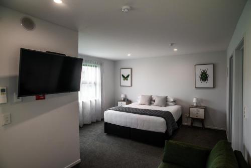 a bedroom with a bed and a flat screen tv at Central Park Apartments in Cromwell