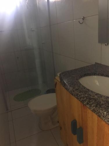 a bathroom with a toilet and a sink at Chalé encontro das aguas in Barra do Cunhau