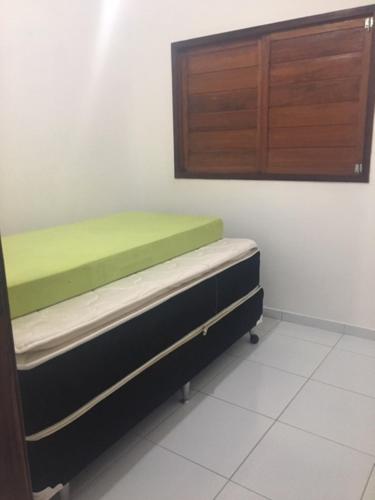 a room with two beds and a wooden cabinet at Chalé encontro das aguas in Barra do Cunhau