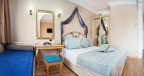 a bedroom with a bed and a desk and a mirror at Pashas Princess by Werde Hotels - Adult Only in Kemer
