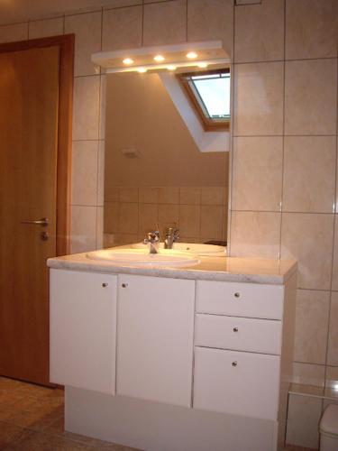 une salle de bain avec un lavabo et un miroir dans l'établissement Gîte du Frankenbourg, à Châtenois