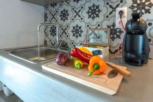 a cutting board with vegetables on a counter next to a sink at Aelia Suites in Adamas