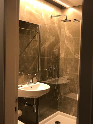 a bathroom with a sink and a shower at Welcome inn Viseu in Viseu
