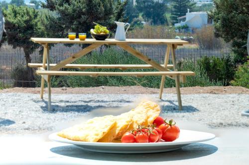 a plate of food with tomatoes on a table at Aelia Suites in Adamas