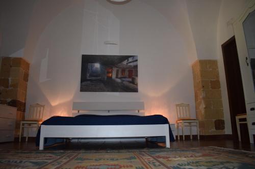 a bedroom with a bed and a painting on the wall at Masseria Convento in Novoli