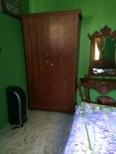 Camera verde con letto e armadietto in legno di Fidigri Homestay a Cikembulan