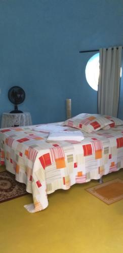 a bed in a blue room with a red and white blanket at Chalé iglu joto in Conceição do Mato Dentro