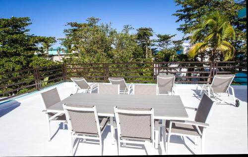 a white dining table and chairs on a patio at The Beach Pad Puntas in Rincon