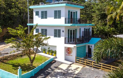 a white house with a blue roof at The Beach Pad Puntas in Rincon