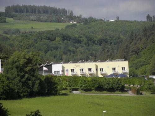 a large white house in a green field with trees at Zur Morschbach in Altlay