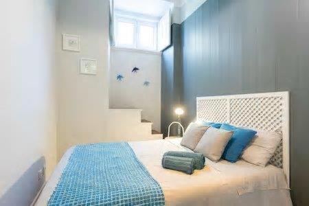 Schlafzimmer mit einem Bett mit blauen und weißen Kissen in der Unterkunft Lisbon Charming Apartment in Lissabon