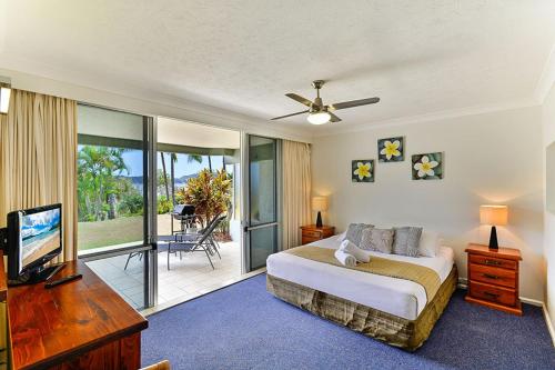 a bedroom with a bed and a flat screen tv at Hibiscus 006 - Hamilton Island in Hamilton Island