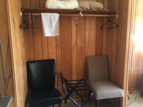 a room with two chairs and a shelf and towels at Tyee Restaurant and Motel in Coupeville