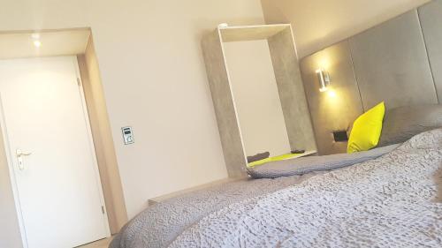 a bedroom with a large bed and a mirror at modern Hoteliving Gießen in Gießen