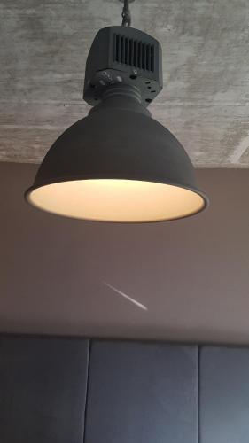 a light hanging from a ceiling in a room at modern Hoteliving Gießen in Gießen