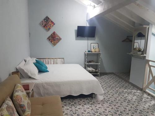 um quarto branco com uma cama e um sofá em Casa Anita em Cartagena das Índias