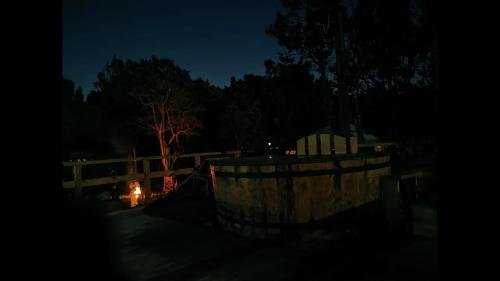 a fence at night with a fire in the background at El Reflejo Lodge Spa - Queilen - Chiloé in Queilén