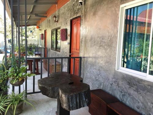 a wooden bench sitting on the side of a building at Muangchaem House in Mae Chaem