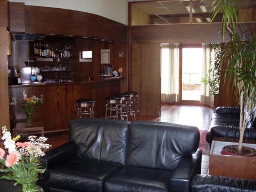 ein Wohnzimmer mit einem schwarzen Ledersofa und einer Bar in der Unterkunft Hotel Isola di Lauria in Lauria Inferiore