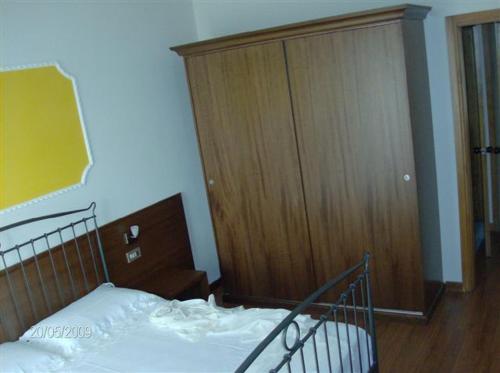 Schlafzimmer mit einem Bett und einem Holzschrank in der Unterkunft Hotel Isola di Lauria in Lauria Inferiore