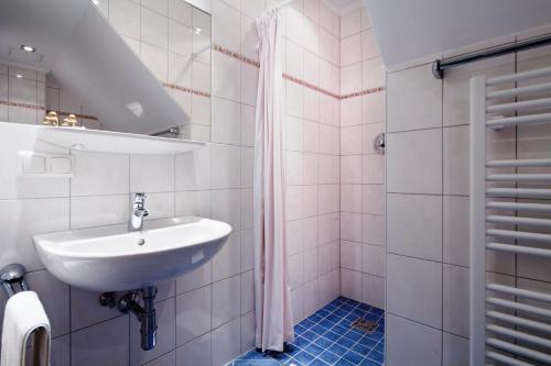 a white bathroom with a sink and a shower at Euro Youth Hotel & Krone in Bad Gastein