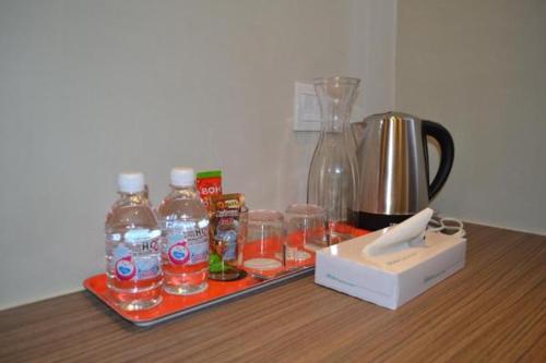 ein Tablett mit Gläsern Wasser und einem Mixer auf dem Tisch in der Unterkunft U Design Hotel Mentakab in Mentekab