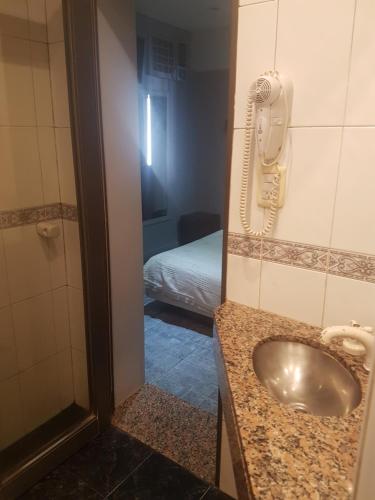 baño con lavabo y teléfono en la pared en Real Horizonte Hotel -Motel- en Don Torcuato