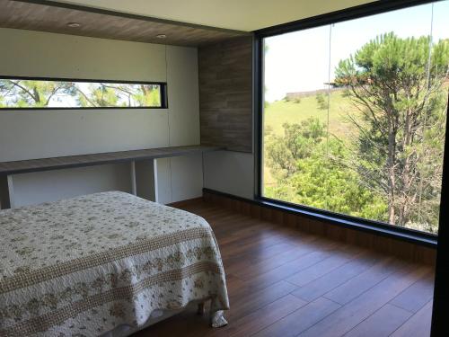 a bedroom with a bed and a large window at Gran casa del lago in Villa Ciudad de America