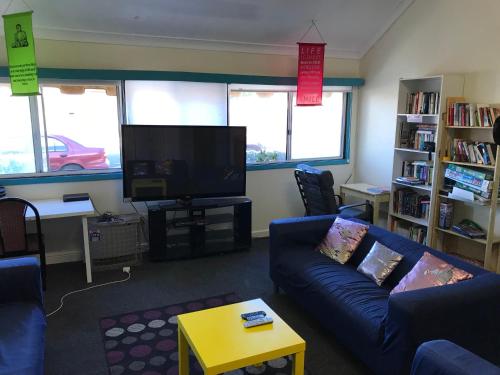 a living room filled with furniture and a tv at Wander Inn Bunbury in Bunbury