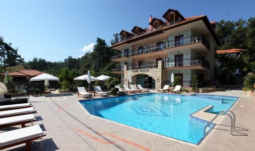 un hôtel avec une piscine en face d'un bâtiment dans l'établissement Glikadi Hotel, à Thasos