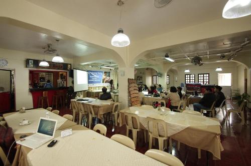 un restaurante con mesas blancas y gente sentada en mesas en Batanes Seaside Lodge & Restaurant, en Basco