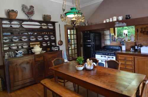 une cuisine avec une table en bois et une salle à manger dans l'établissement La Source, Beynac, Dordogne, à Beynac-et-Cazenac